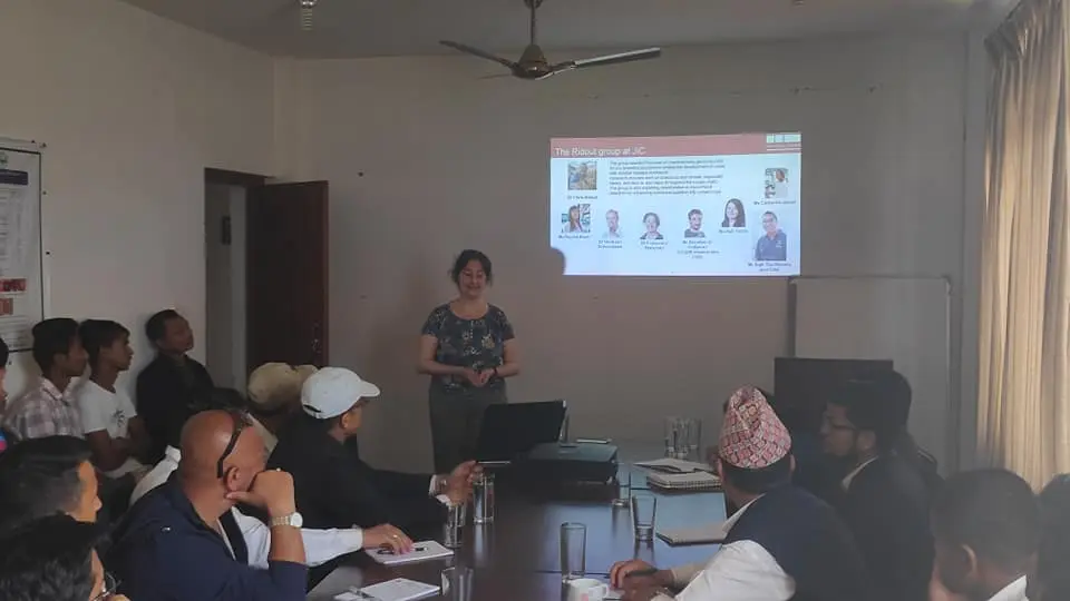 Team member presenting project findings to a seated group during a training workshop